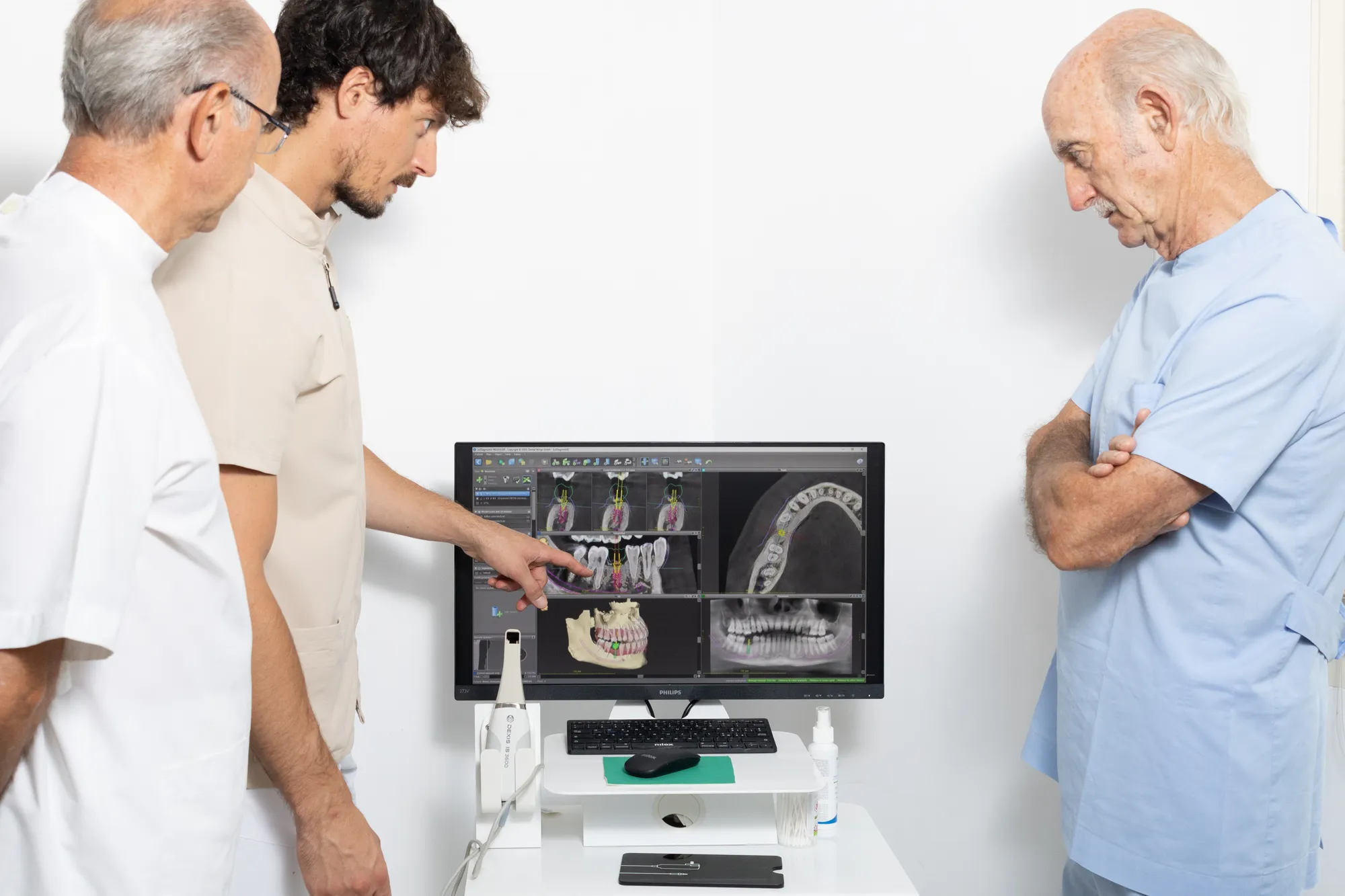 Tre medici di Odontos esaminano le immagini radiografiche sul monitor