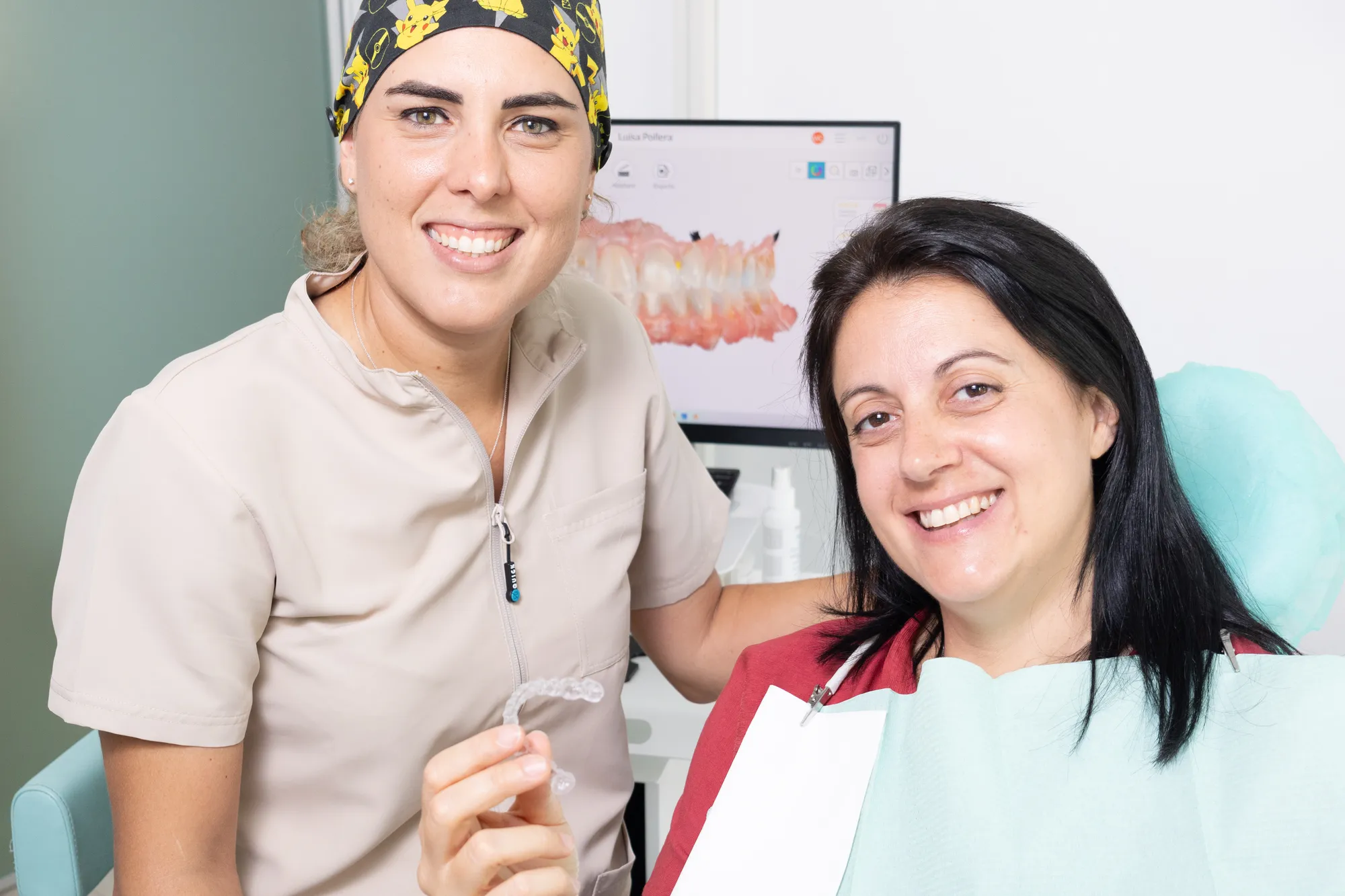 Un’ortodontista di Odontos con una paziente sorridente e un allineatore trasparente